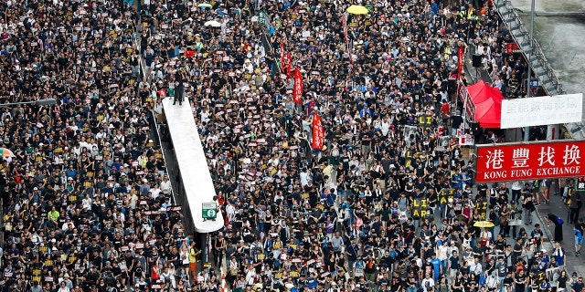 Protesters take part in a march on a street in Hong Kong, Sunday, July 21, 2019. Thousands of Hong Kong protesters marched from a public park to call for an independent investigation into police tactics. (AP Photo/Vincent Yu)