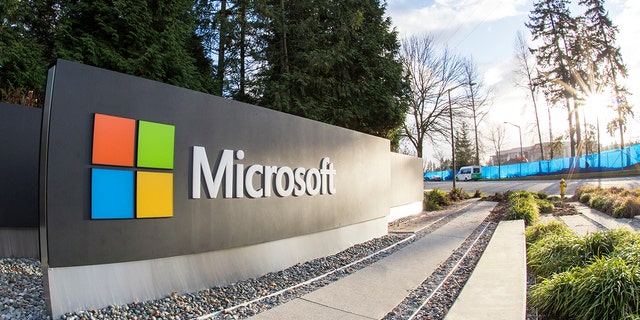  One of the biggest Microsoft signs is placed next to green trees at a public intersection near Microsoft's Redmond campus