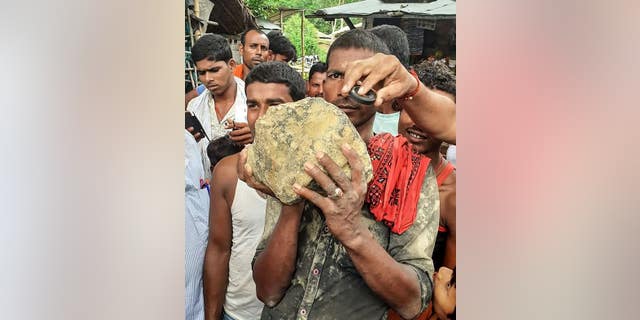 A villager holds the suspected meteorite.