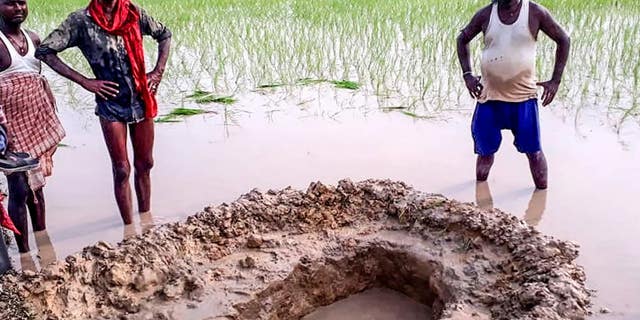 The mysterious object was seen by local residents and then excavated from this hole. (STR/AFP/Getty Images)