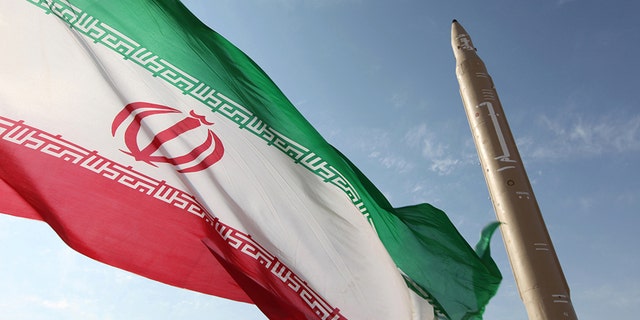 Photo du dossier - Une photo prise le 20 août 2010 montre un drapeau iranien flottant sur un endroit non divulgué de la république islamique à côté d'un missile sol-sol Qiam-1 (Rising) qui avait été mis à l'essai la veille de la mort de l'Iran lance sa première centrale nucléaire construite en Russie. 