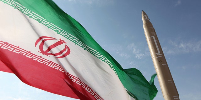 Photo du dossier - Une photo prise le 20 août 2010 montre un drapeau iranien flottant sur un endroit non divulgué de la république islamique à côté d'un missile sol-sol Qiam-1 (Rising) qui avait été mis à l'essai la veille de la mort de l'Iran lance sa première centrale nucléaire construite en Russie. 