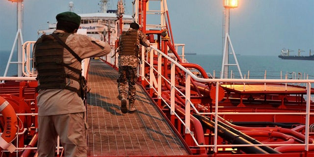 Two armed members of Iran's Revolutionary Guard inspect the British-flagged oil tanker Stena Impero, which was seized in the Strait of Hormuz on Friday by the Guard, in the Iranian port of Bandar Abbas. (AP/Mehr News Agency)