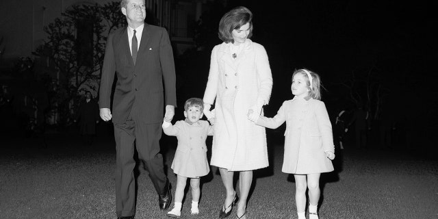 Jackie and John Kennedy walk with their two children, John and Caroline. (Getty)