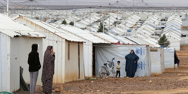 Syrian refugee women stand in front of their homes at Azraq refugee camp, near Al Azraq city, Jordan, December 8, 2018. 