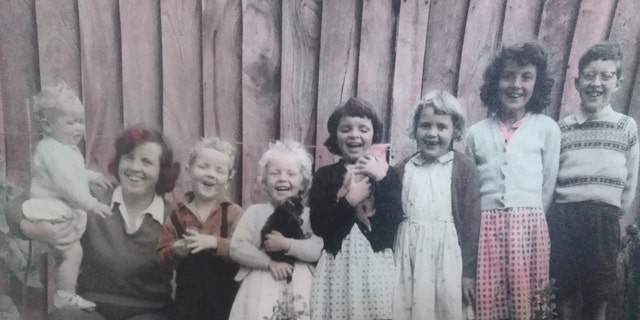 A family photo of Aldrin standing on his mother Diana West's leg with his brothers and sisters.