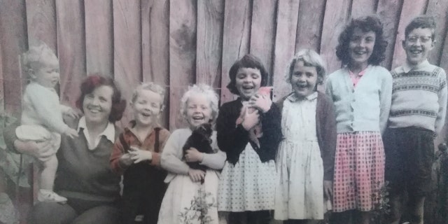 A family photo of Aldrin standing on his mother Diana West's leg with his brothers and sisters.