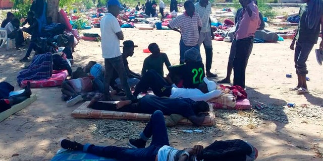 People rest outside at the detention center following the airstrike, which killed at least 44 migrants. (AP)