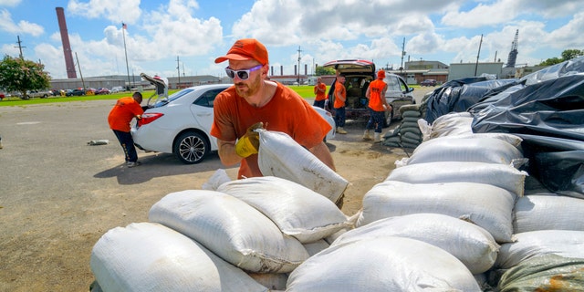 St. Bernard Parish Sheriff's Office inmate workers move free sandbags for residents in Chalmette, La., Thursday, July 11, 2019. The Mississippi Emergency Management Agency is telling people in the southern part of the state to be prepared for heavy rain from Tropical Storm Barry as it pushes northward through the Gulf of Mexico. (AP Photo/Matthew Hinton)