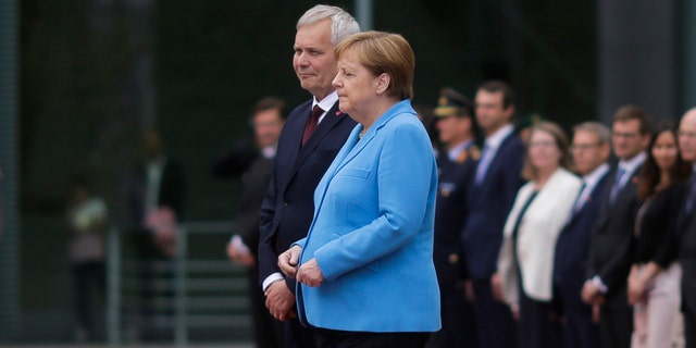 German Chancellor Angela Merkel and Prime Minister of Finland Antti Rinne listen to the national anthems at the chancellery in Berlin, Germany, Wednesday, July 10, 2019. (AP Photo/Markus Schreiber)