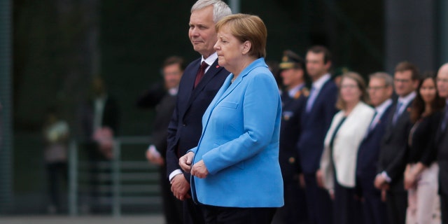 German Chancellor Angela Merkel and Prime Minister of Finland Antti Rinne listen to the national anthems at the chancellery in Berlin, Germany, Wednesday, July 10, 2019. (AP Photo/Markus Schreiber)