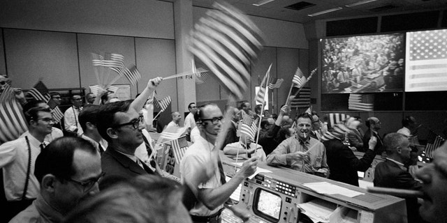 S69-40022 (24 July 1969) --- Overall view of the Mission Operations Control Room (MOCR) in the Mission Control Center (MCC), Building 30, Manned Spacecraft Center (MSC), showing the flight controllers celebrating the successful conclusion of the Apollo 11 lunar landing mission. (Credit: NASA)