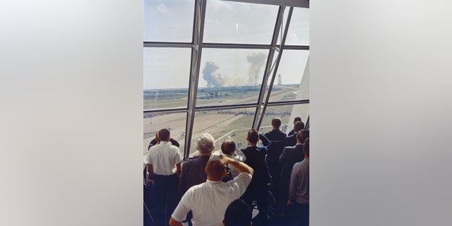 Personnel within the Launch Control Center watch the Apollo 11 liftoff from Launch Complex 39A today at the start of the historic lunar landing mission. The LCC is located three and one-half miles from the launch pad. (Credit: NASA)