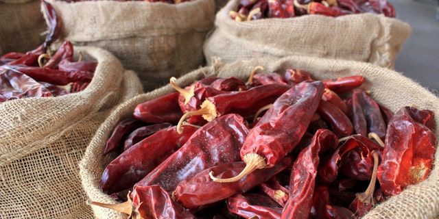 FILE - This March 20, 2013, file photo, shows sacks of dried red chile pods at the Hatch Chile Sales shop along the main street of the self-proclaimed "Chile Capital of the World," in Hatch, N.M. A hybrid version of a New Mexico chile plant has been selected to be grown in space as part of a NASA experiment, officials recently announced. (AP Photo/Susan Montoya Bryan, File)