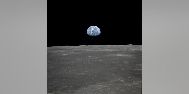 This view of Earth rising over the moon's horizon was taken from the Apollo spacecraft. The lunar terrain pictured is in the area of Smyth's Sea on the nearside. Coordinates of the center of the terrain are 85 degrees east longitude and 3 degrees north latitude. (Credit: NASA)