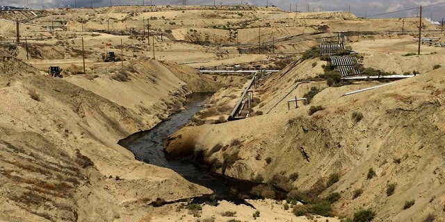 In this May 10, 2019 photo provided by California's Office of Spill Prevention and Spill Response, oil is flowing into a Chevron oil field in Kern County, California. Nearly 800,000 gallons of oil and water have been flowing from the ground since May. (Office of Spill Prevention and Spill Response via the California Department of Fish and Wildlife)