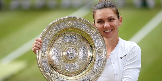Simona Halep of Romania poses for a photo with her trophy after winning the women's singles final against Serena Williams of the United States on the twelfth day of the championships - Wimbledon 2019 at All England Lawn Tennis and Croquet Club on July 13, 2019 in London, England. (Photo by Mike Hewitt / Getty Images)