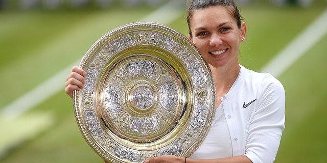 Simona Halep of Romania pose for a photo with her trophy after winning the Ladies' Singles final against Serena Williams of The United States during Day twelve of The Championships - Wimbledon 2019 at All England Lawn Tennis and Croquet Club on July 13, 2019 in London, England. (Photo by Mike Hewitt/Getty Images)