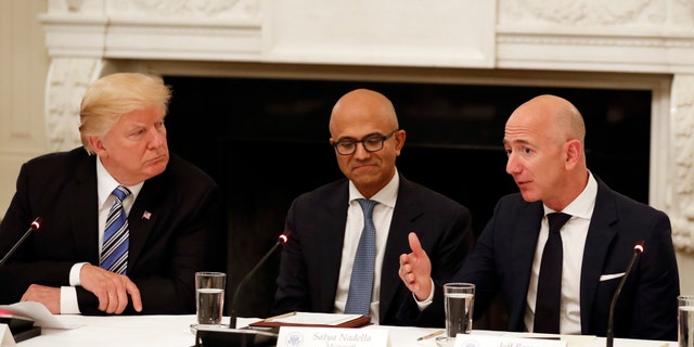 FILE - In this June 19, 2017, file photo President Donald Trump, left, and Satya Nadella, Chief Executive Officer of Microsoft, center, listen as Jeff Bezos, Chief Executive Officer of Amazon, speaks during an American Technology Council roundtable in the State Dinning Room of the White House in Washington. (AP Photo/Alex Brandon, File)