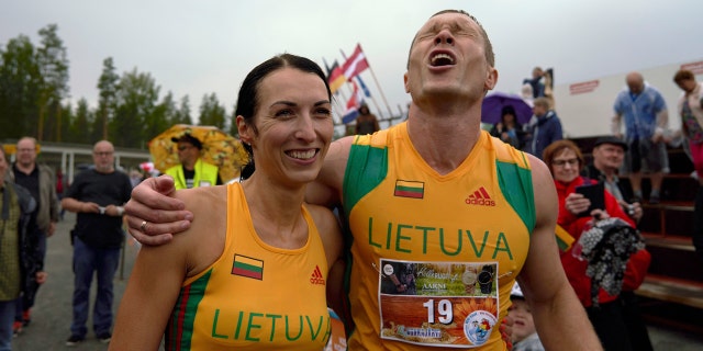 Lithuanian couple Vytautas Kirkliauskas, right, and Neringa Kirkliauskiene celebrate their victory in the wife carrying race, a 278-yard obstacle course, during the 24th world championships in Sonkajarvi, Finland, Saturday, July 6, 2019. (AP Photo/David Keyton)