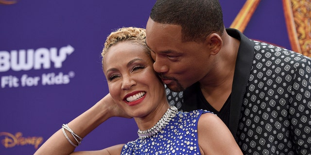 Will Smith, right, kisses Jada Pinkett Smith as they arrive at the premiere of 
