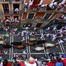 Revelers run next to fighting bulls during the running of the bulls at the San Fermin Festival, in Pamplona, Spain, July 12, 2019.