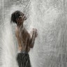 A boy plays in a fountain to cool off as temperatures approach 100 degrees Fahrenheit in Kansas City, July 18, 2019. 