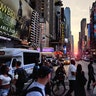 People cross 42nd Street as the sun sets in New York City, July 10, 2019.