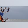 Boys jump into the water after a strong downpour at Manila's Bay, Philippines, July 17, 2019. 