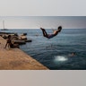 A boy jumps into the water at the beach in Barcelona, Spain, July 25, 2019. 