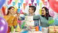 Cheerful teenagers celebrating a birthday and making a toast