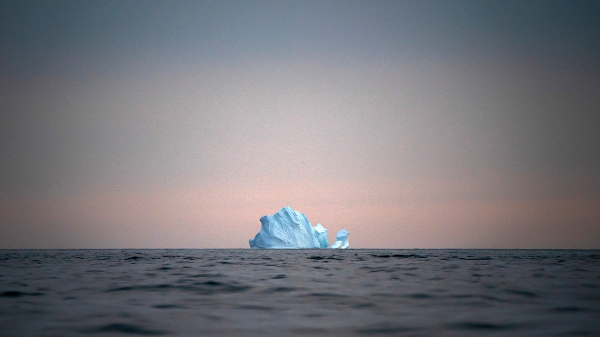 In this Aug. 15 photo, a large Iceberg floats away as the sun sets near Kulusuk, Greenland.  (AP Photo/Felipe Dana)