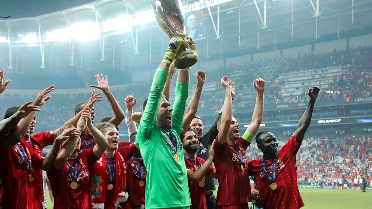 Liverpool's goalkeeper Adrian lifts up the trophy as he celebrates with players after winning the UEFA Super Cup soccer match between Liverpool and Chelsea, in Besiktas Park.