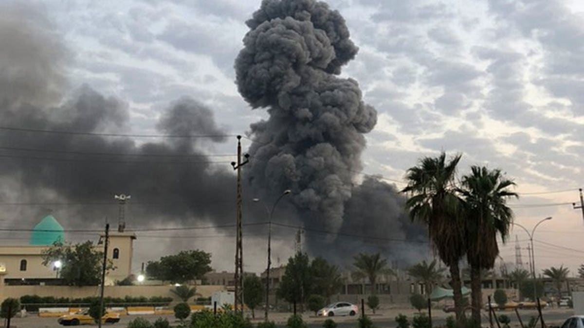 In this Monday, Aug. 12, 2019 file photo, plumes of smoke rise after an explosion at a military base southwest of Baghdad, Iraq. A fact-finding committee appointed by the Iraqi government to investigate a massive munitions depot explosion near the capital Baghdad has concluded that the blast was the result of a drone strike.