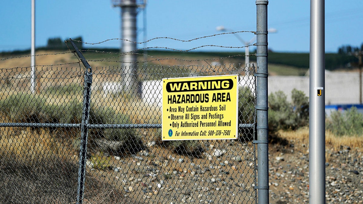 A sign at the Hanford Nuclear Reservation warning of possible hazards in the soil there along the Columbia River near Richland, Wash. (AP Photo/Elaine Thompson)