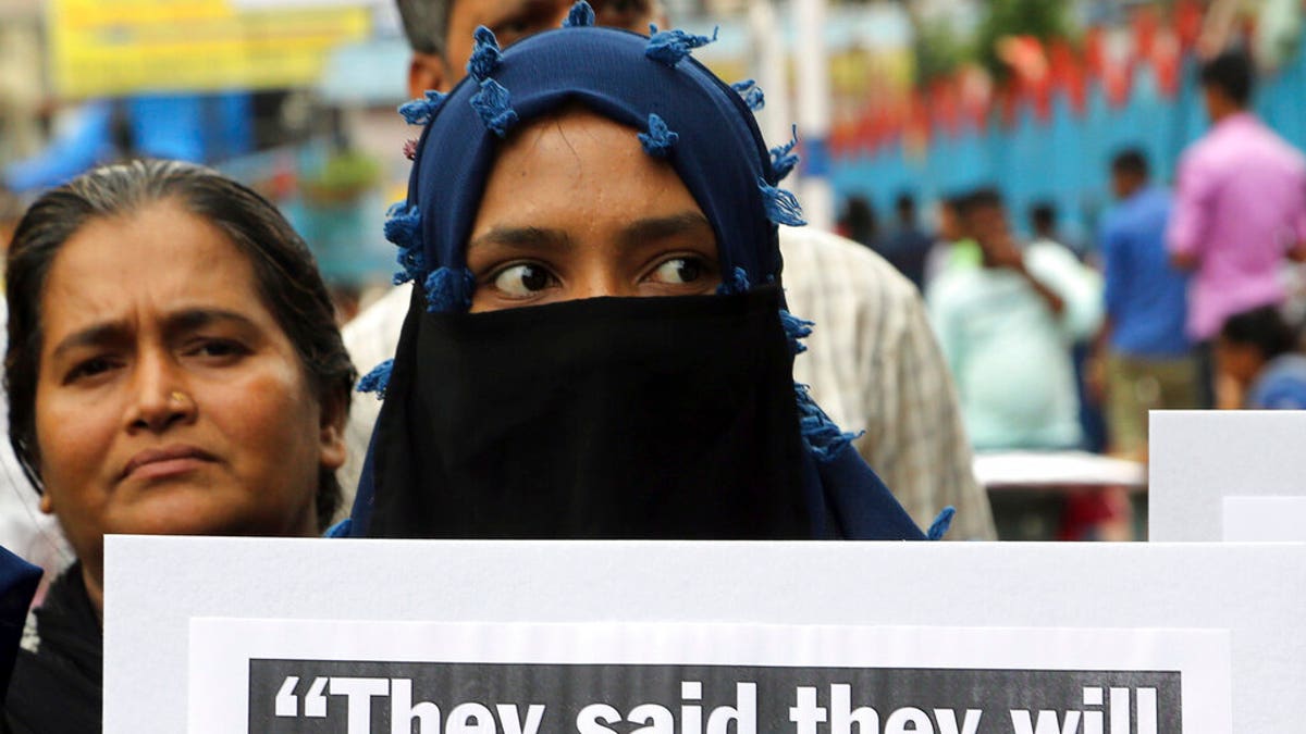 An Indian woman holds a placard during a protest to condemn a deadly car crash that left a woman who accused a politician of rape in critical condition, in Mumbai, India, on Thursday.