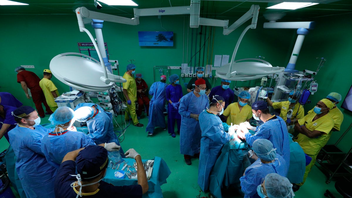 In this Aug. 1, 2019 photograph provided by Action for Defenceless People Foundation, Hungarian doctors Gergely Pataki, left, and Andras Csokay perform separation surgery on Rabeya and Rukaya. (Andras Taborosi/Action for Defenceless People Foundation via AP)
