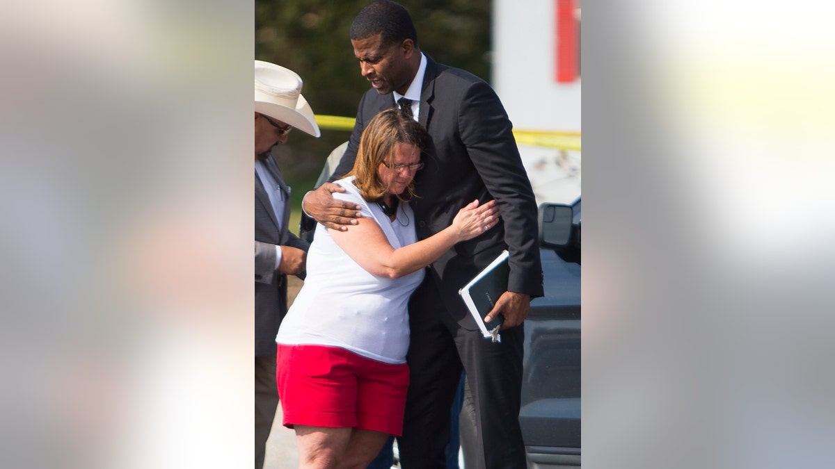 FILE - In this Nov. 6, 2017, file photo Sherri Pomeroy, wife of Pastor Frank Pomeroy, who lost their daughter in a mass shooting at the First Baptist Church of Sutherland Springs, Texas, hugs Pastor Dimas Salaberrios before a news conference in Sutherland Springs. Pomeroy sought to boost his followers' resolve with upbeat remarks at Sunday's service. He urged them not to live "in a spirit of fear. (Mark Mulligan/Houston Chronicle via AP, File)