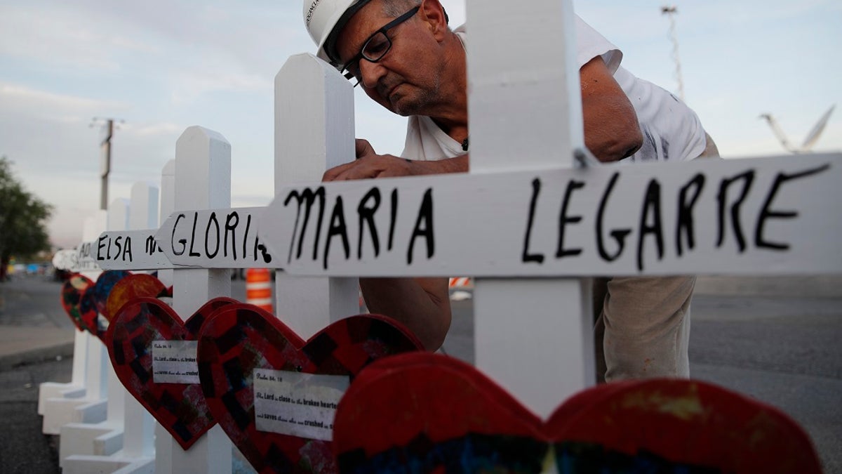 Greg Zanis prepares crosses to place at a makeshift memorial for victims of a mass shooting at a shopping complex Monday in El Paso, Texas. (AP Photo/John Locher)