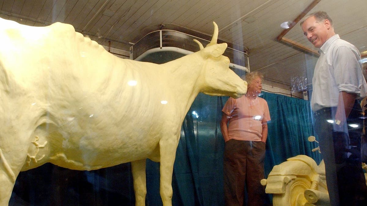 FILE - In this Aug. 14, 2003, file photo, Democratic presidential hopeful Howard Dean, right, inspects the butter cow with creator Norma "Duffy" Lyons during a visit to the Iowa State Fair in Des Moines, Iowa. (AP Photo/Charlie Neibergall, File)