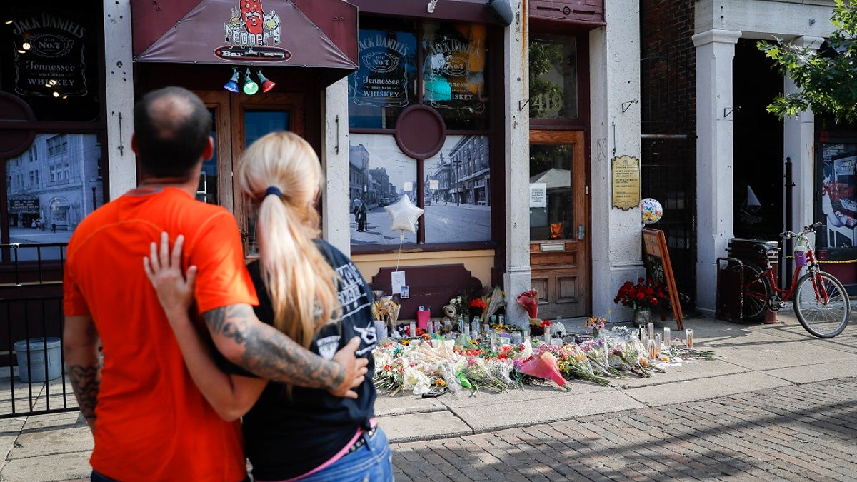 Mourners pause at a makeshift memorial for the slain and injured outside Ned Peppers bar in the Oregon District after a mass shooting in Dayton, Ohio.