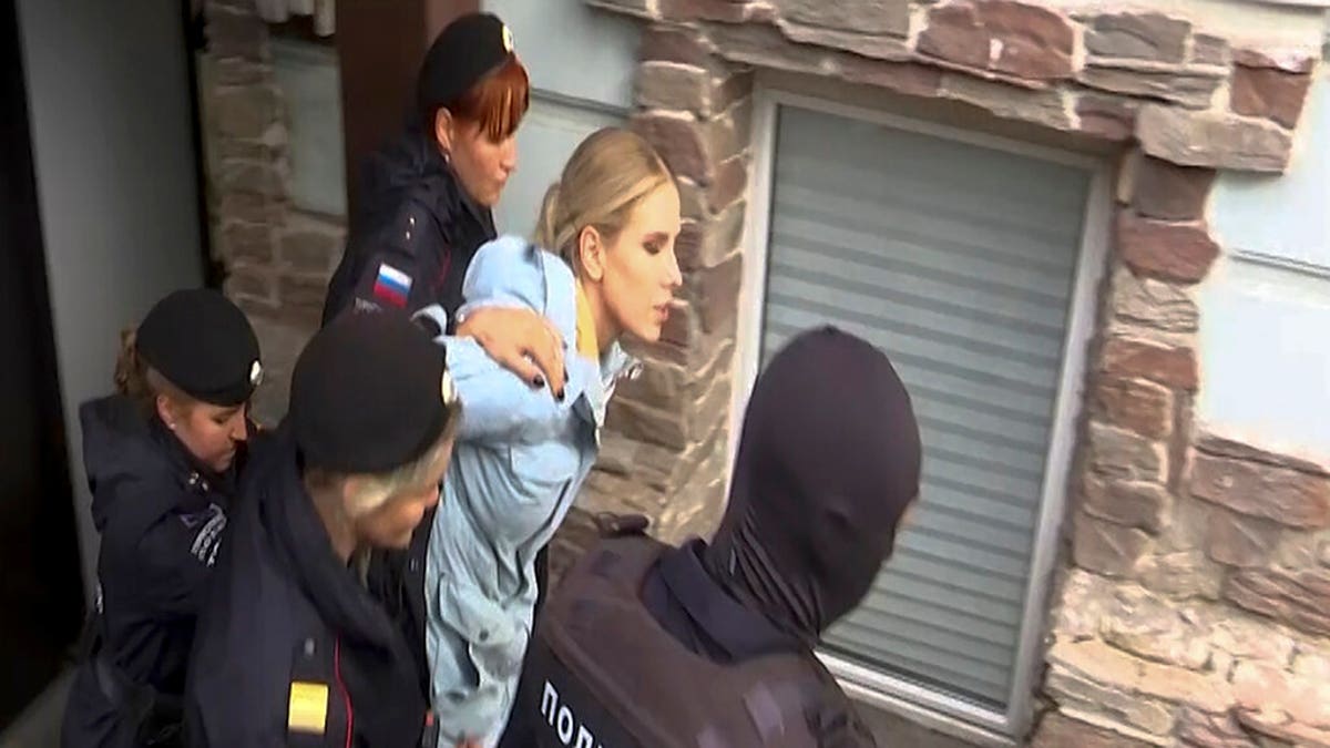 Police officers detaining Russian opposition activist Lyubov Sobol near her office in Moscow, Russia, Saturday, Aug. 10, 2019.