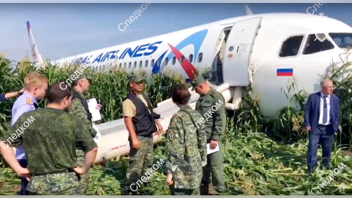 In this file image taken from a video distributed by Russian Investigative Committee, Investigative Committee employees work at the crash site of a Russian Ural Airlines' A321 plane is seen after an emergency landing in a cornfield near Ramenskoye, outside Moscow, Russia, Thursday, Aug. 15, 2019.