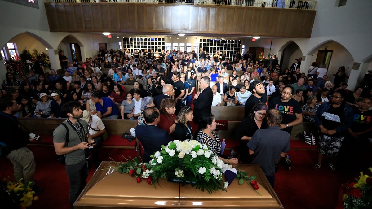 People offering condolences to Antonio Basco, lower right, at her funeral at La Paz Faith Memorial and Spiritual Center in El Paso this past Friday. (AP Photo/Jorge Salgado)