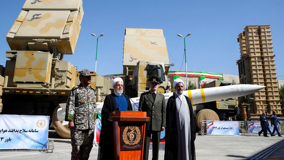 Iran's President Hassan Rouhani, second left, speaks during a ceremony to unveil the Iran-made Bavar-373, a long-range surface-to-air missile system at an undisclosed location in Iran, Thursday, Aug. 22, 2019. 