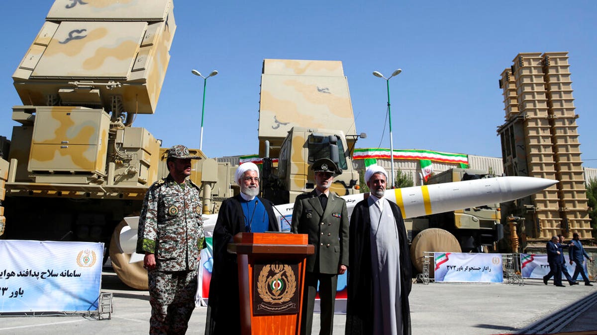 Iran's President Hassan Rouhani, second left, speaks during a ceremony to unveil the Iran-made Bavar-373, a long-range surface-to-air missile system at an undisclosed location in Iran, Thursday, Aug. 22, 2019.?