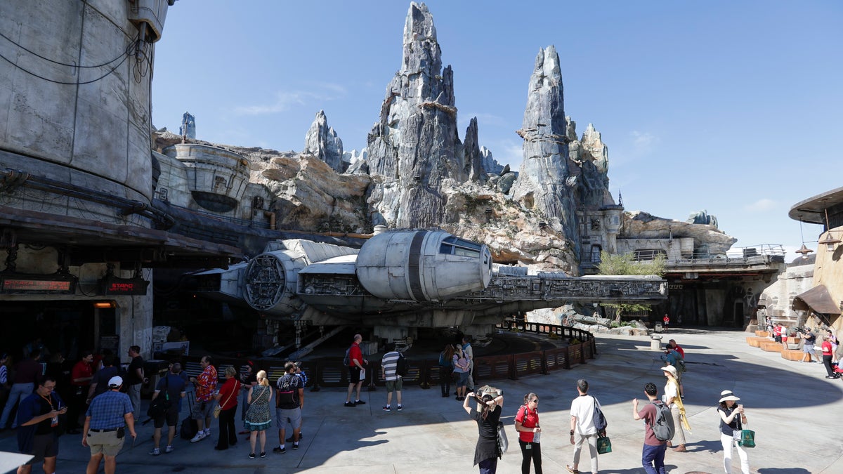 Park visitors walk near the entrance to the Millennium Falcon Smugglers Run ride during a preview of the Star Wars themed land, Galaxy's Edge in Hollywood Studios at Disney World, Tuesday, Aug. 27, 2019, in Lake Buena Vista, Fla. The attraction will open Thursday to park guests. (AP Photo/John Raoux)