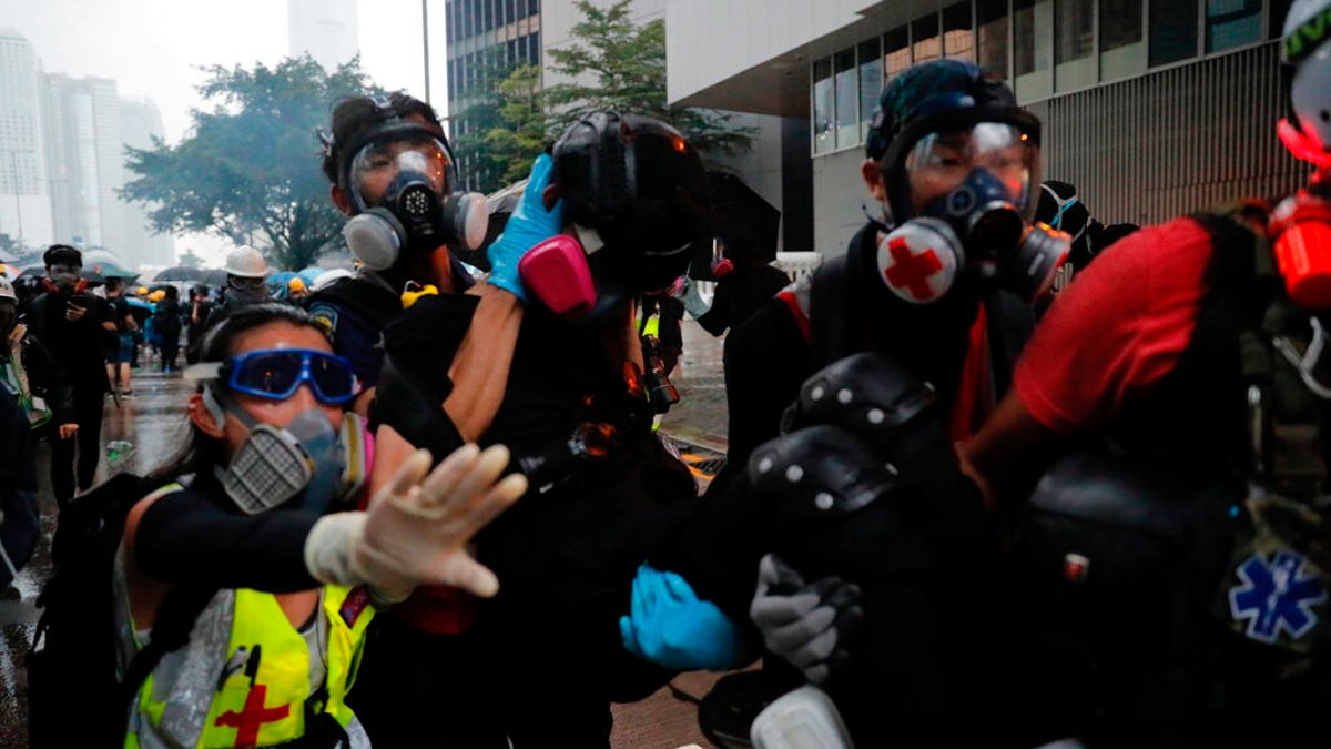 Protestors carry an injured to safety in Hong Kong, Saturday, Aug. 31, 2019. Many of the protesters outside Hong Kong government headquarters have retreated as large contingents of police arrive on the streets in what looks like preparation for a clearing operation. Police were using tear gas Saturday to drive back remaining protesters.