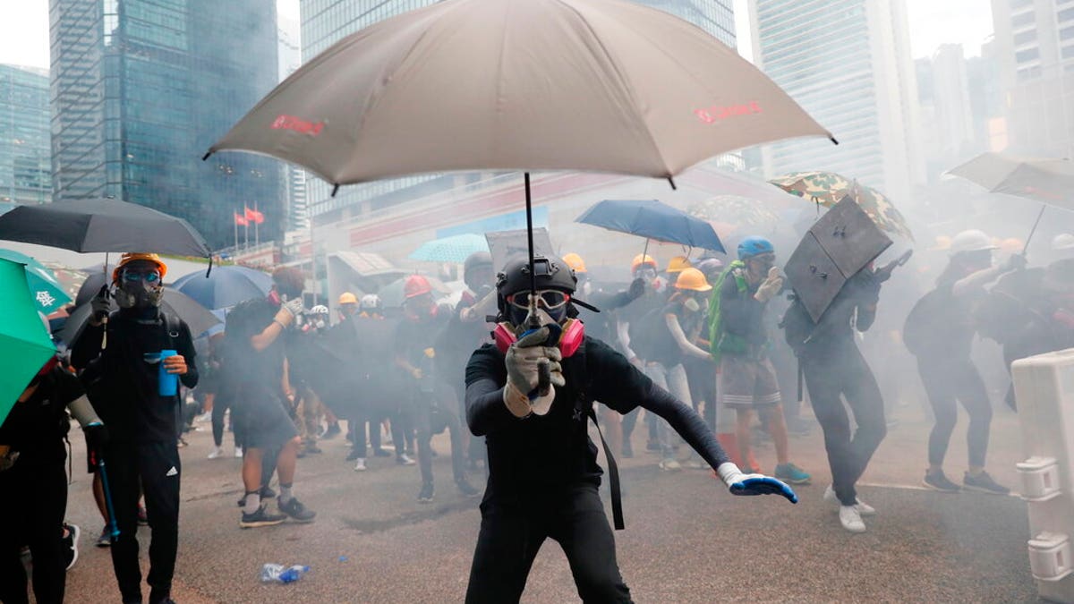 Protestors run for cover from tear gas shells in Hong Kong, Saturday, Aug. 31, 2019. Many of the protesters outside Hong Kong government headquarters have retreated as large contingents of police arrive on the streets in what looks like preparation for a clearing operation. Police were using tear gas Saturday to drive back remaining protesters.