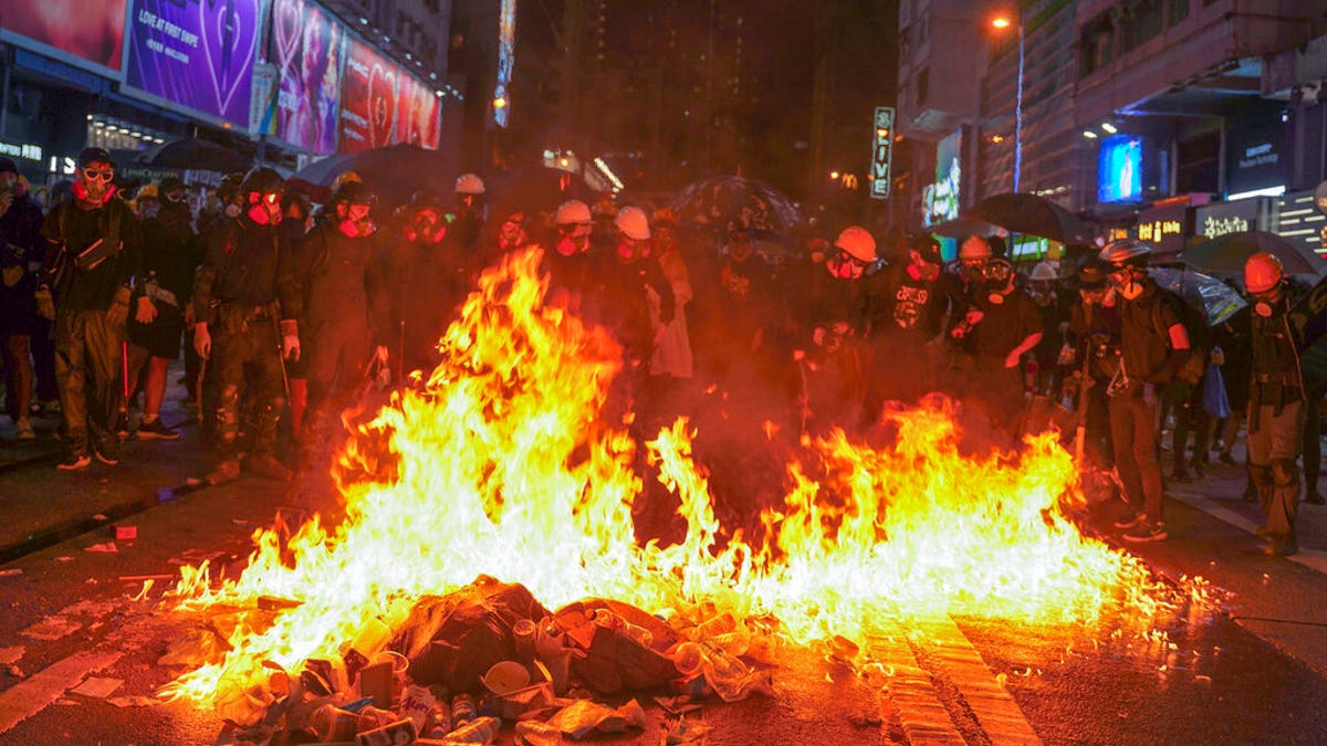 Protesters stand near burning items during a pro-democracy protest in causeway bay, Hong Kong, Saturday, Aug. 31, 2019.